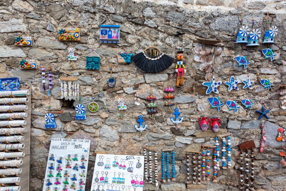 Vibrant handmade crafts and souvenirs displayed on a rustic stone wall, perfect for travel and decor themes.