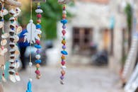 模糊的街道背景下，贝壳和珠子悬挂着，充满活力