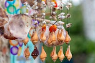 户外的贝壳风铃悬挂着，充满活力地展示着复杂的手工设计