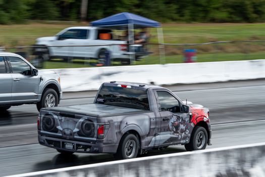Action-packed scene of trucks racing on an outdoor track, highlighting speed and excitement.