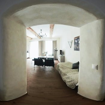 A spacious rustic living room with natural light and wooden beams offering a cozy atmosphere.