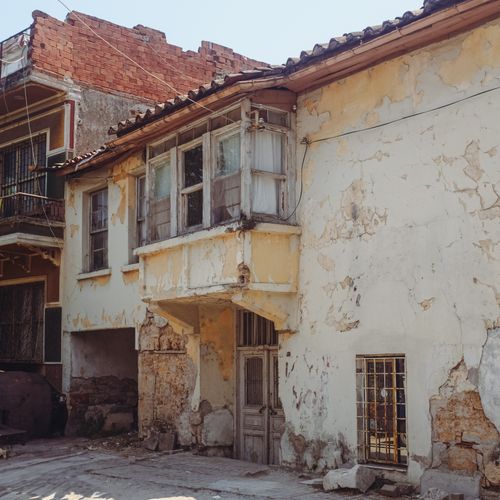 Free Abandoned old house with crumbling facade in sunny urban setting. Stock Photo