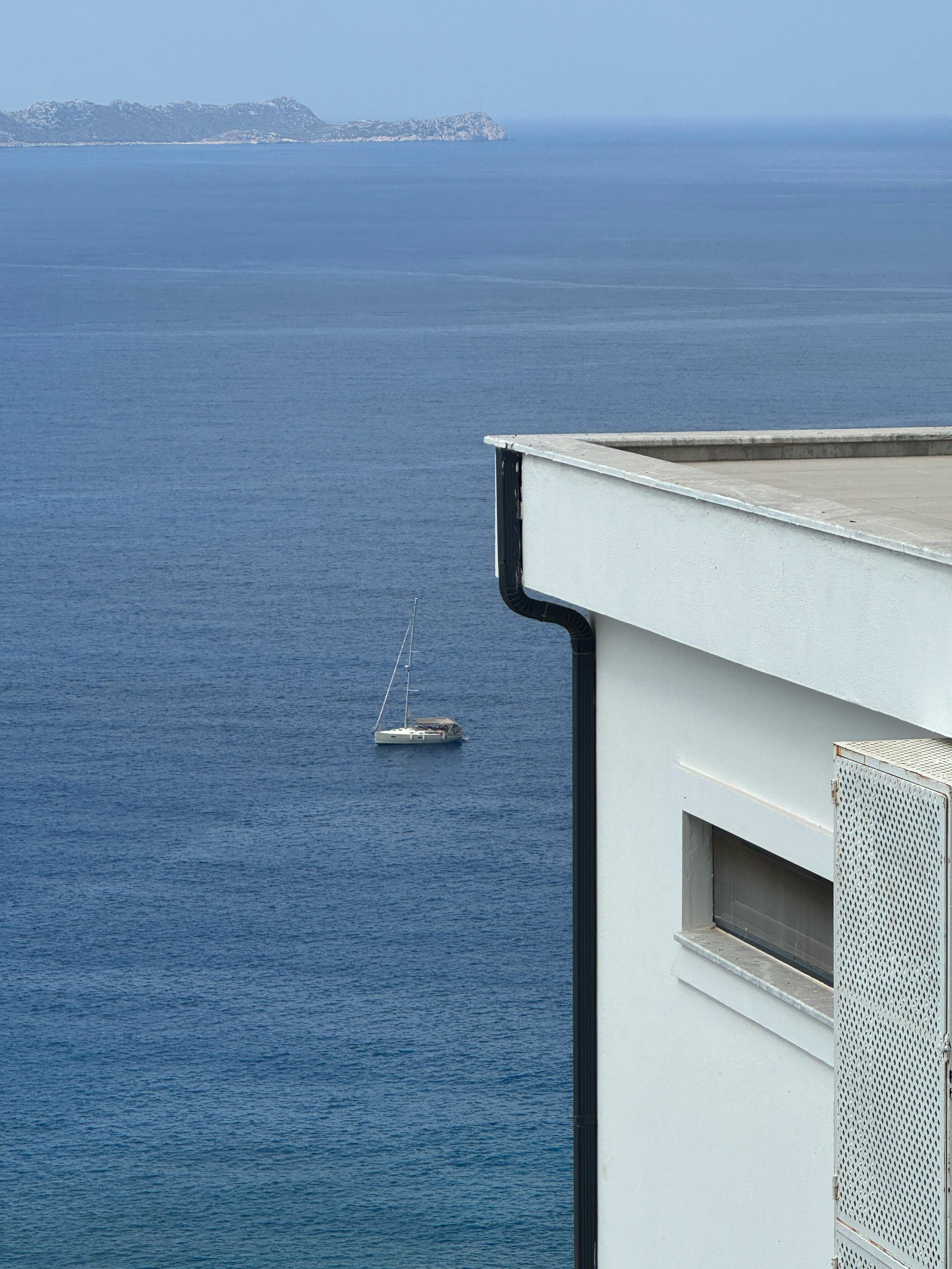 宁静的海景中，游艇和现代建筑阳台的一部分相得益彰