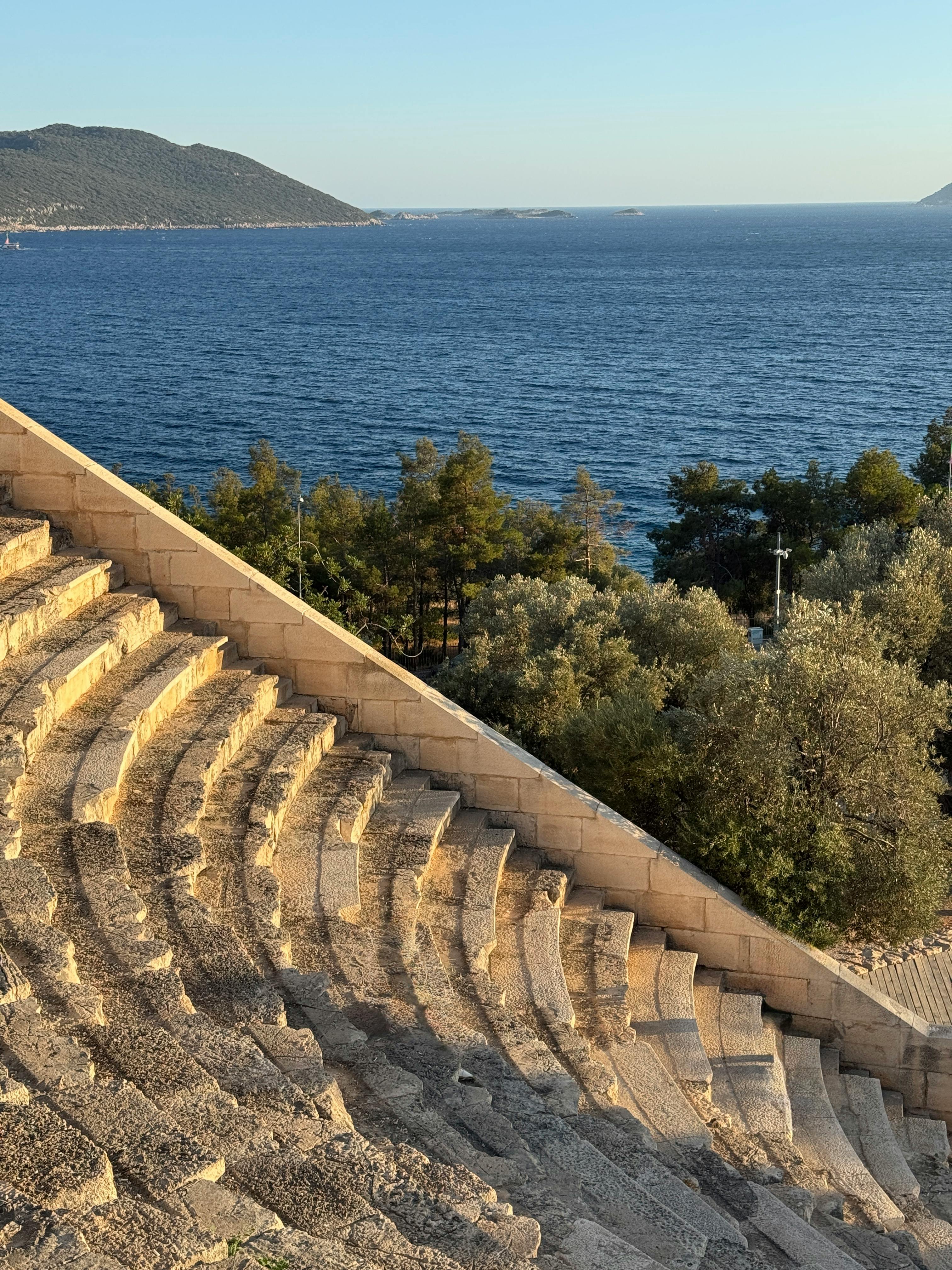 Ücretsiz Yemyeşil doğa ve kıyı sularıyla antik bir amfi tiyatronun muhteşem manzarası. Stok Fotoğraflar