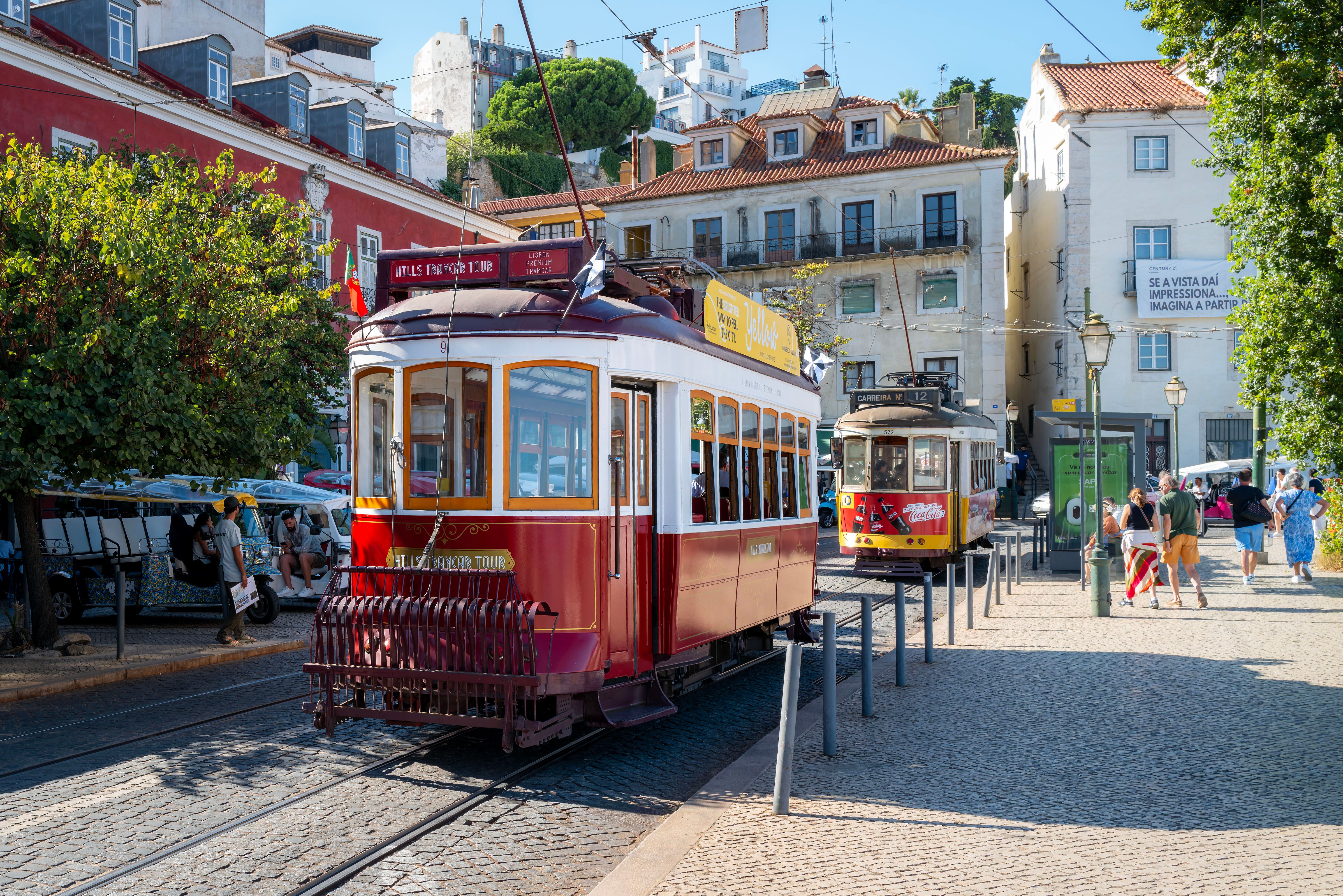 Vintage trams in Lisbon's historic Alfama district, showcasing iconic architecture and summer sightseeing in Portugal.