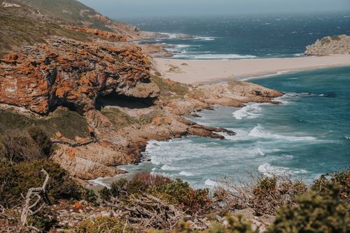 Free Breathtaking view of rocky cliffs and turquoise sea waves on a sunny day at a picturesque coastline. Stock Photo