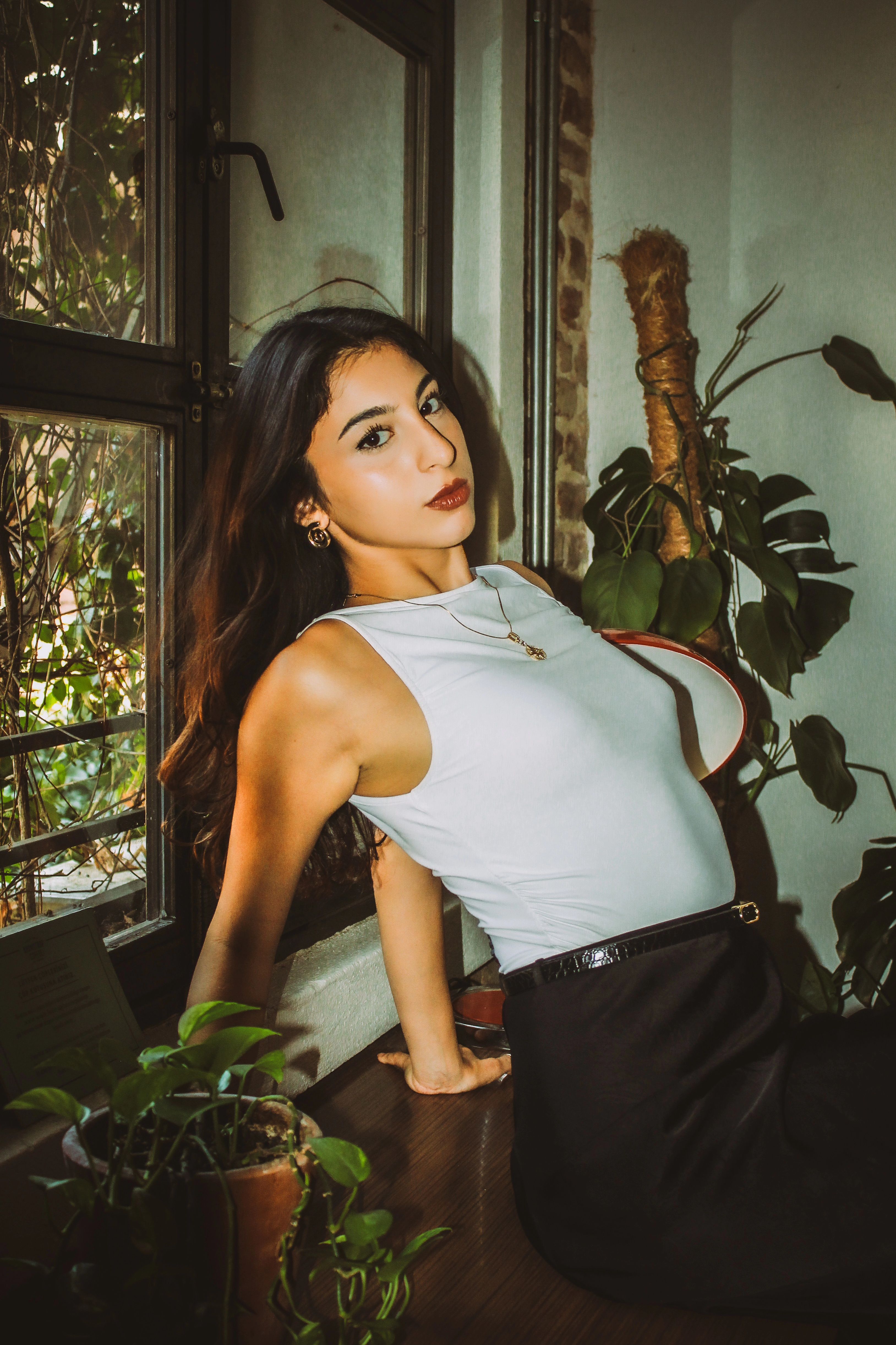 Stylish Woman Posing Indoors with Plants · Free Stock Photo