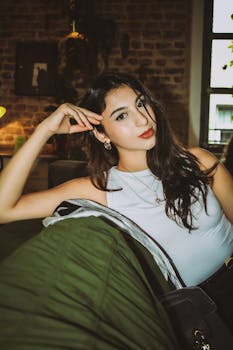 一位时尚的年轻女性自信地摆出姿势，营造出室内的轻松时尚氛围