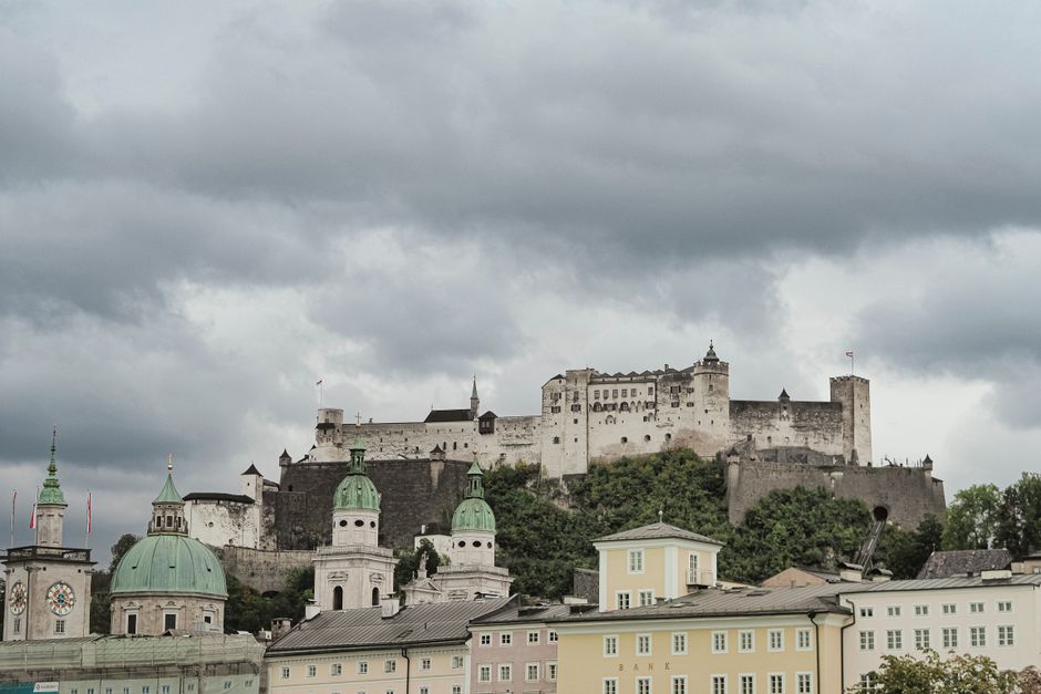 People with umbrellas walking through the historic old town of Salzburg, Austria, on a rainy day