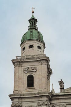 Historic tower of St. Peter's Church with architectural details in Salzburg, Austria.