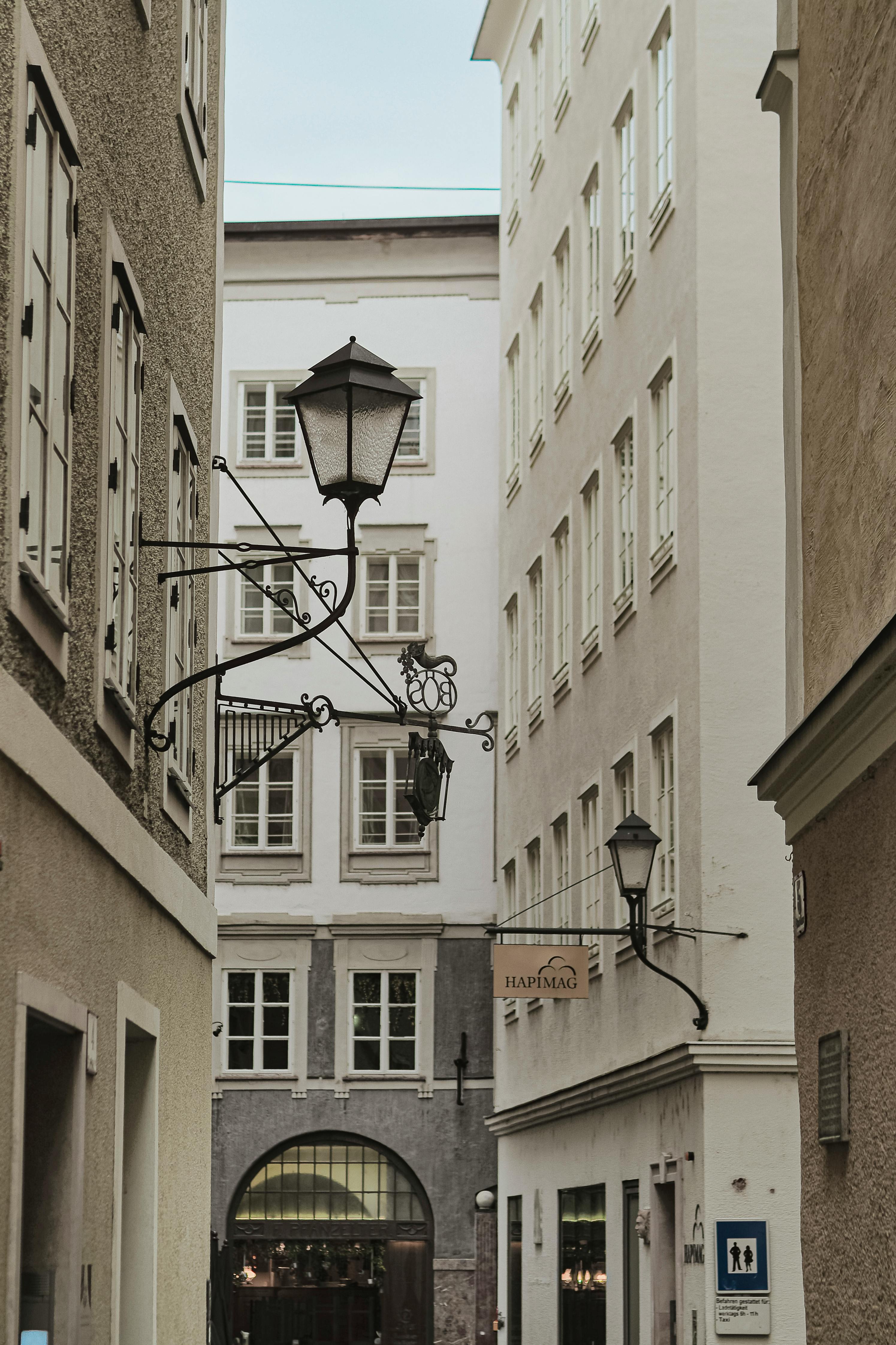 Discover the enchanting charm of a narrow alley in Salzburg, Austria, featuring classic street lamps and historic architecture.