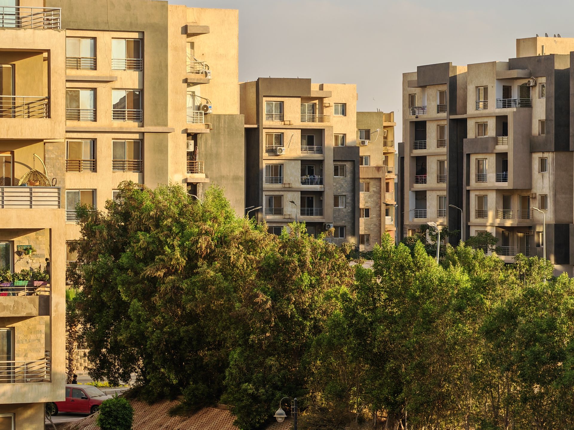 A scenic view of urban apartment buildings with lush greenery in daylight.