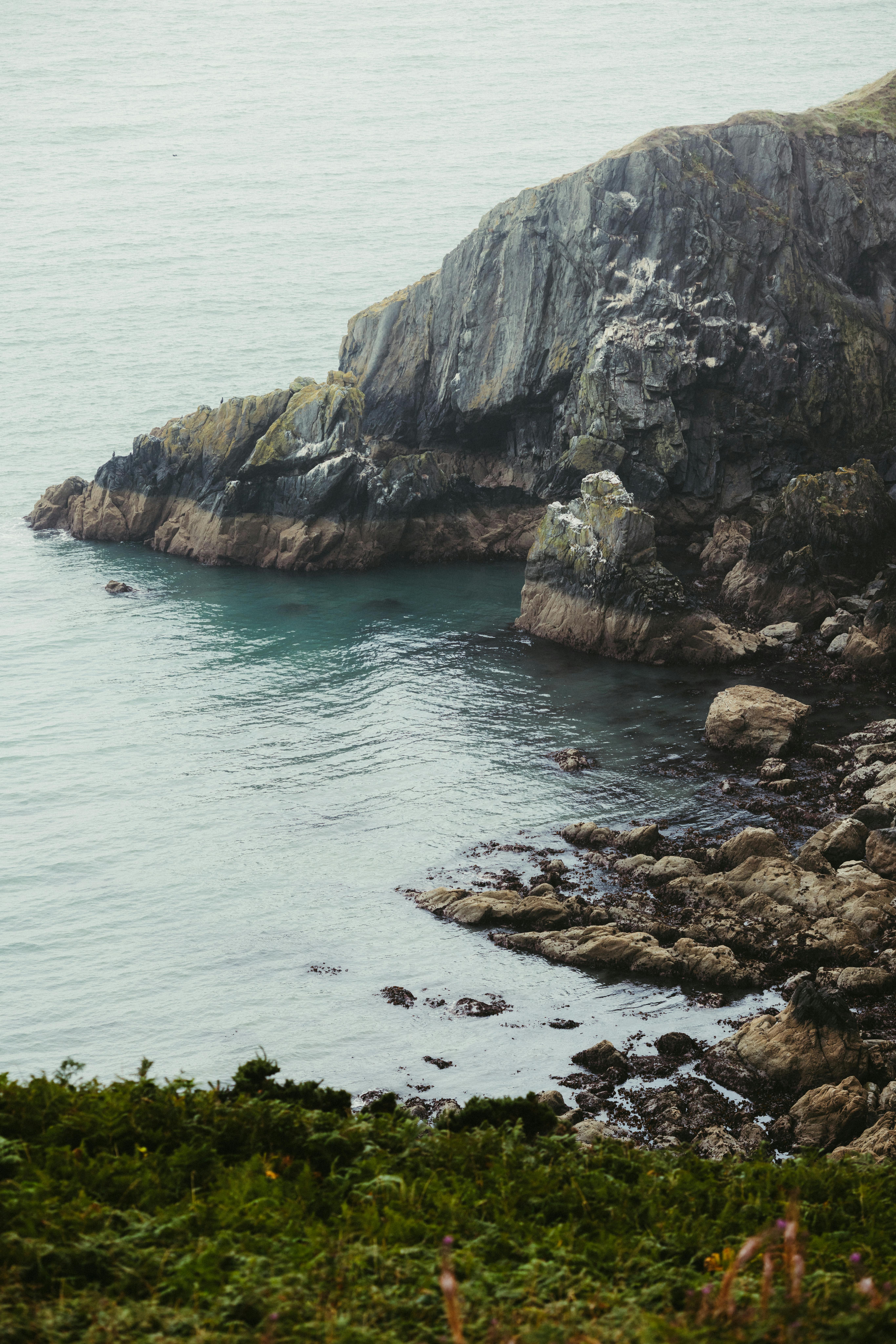 宁静的岩石悬崖位于平静的海洋上，提供宁静的沿海景观