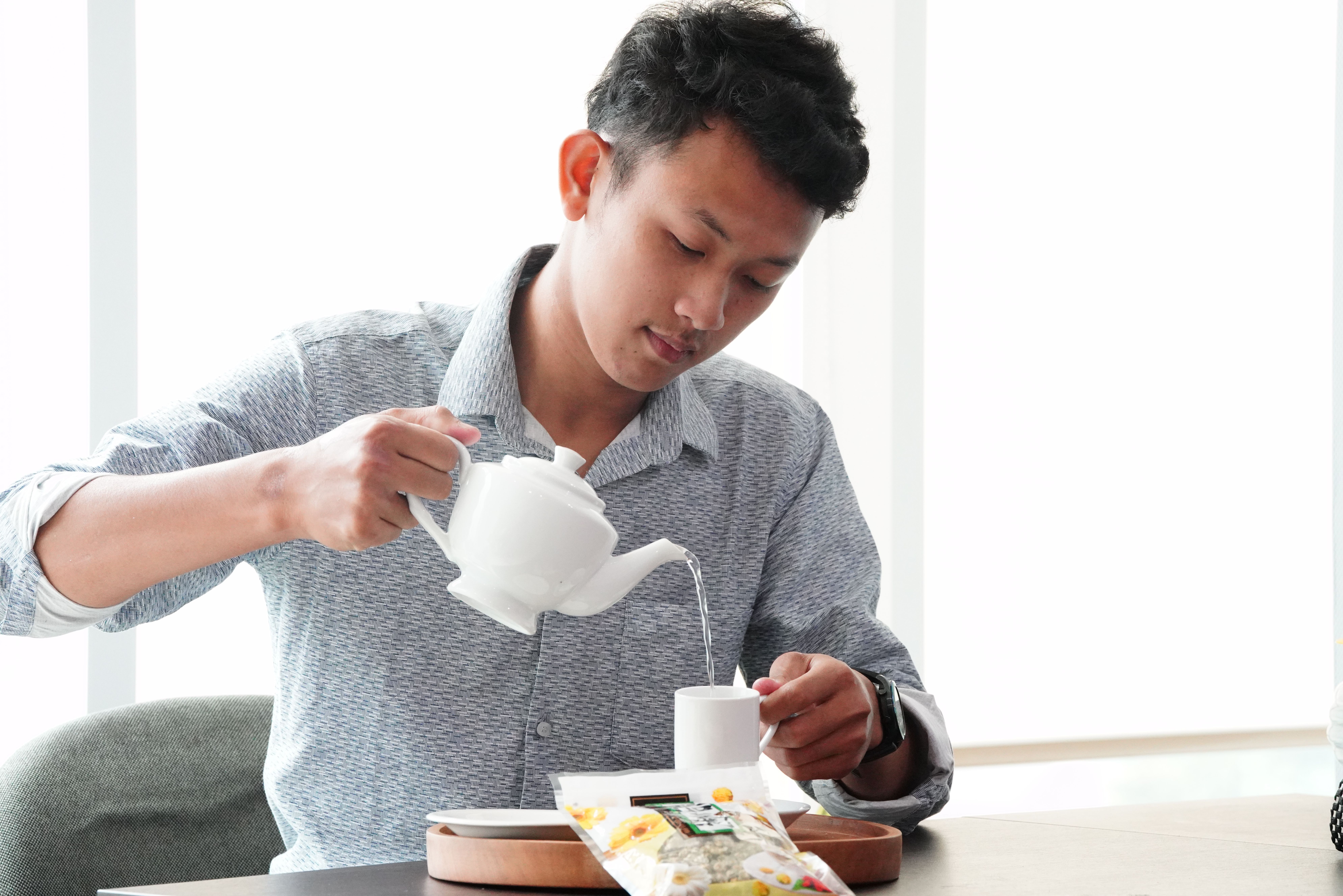 Man Pouring Tea in Bright Indoor Setting · Free Stock Photo