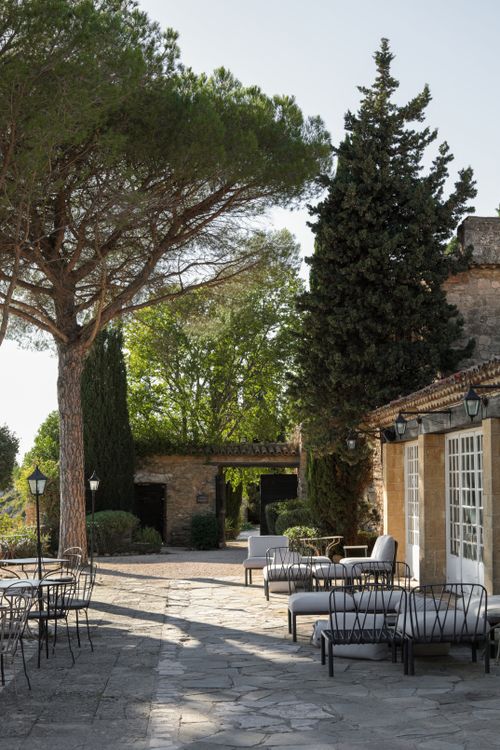 Free Elegant courtyard with outdoor seating and trees in Provence, France, under bright daylight. Stock Photo