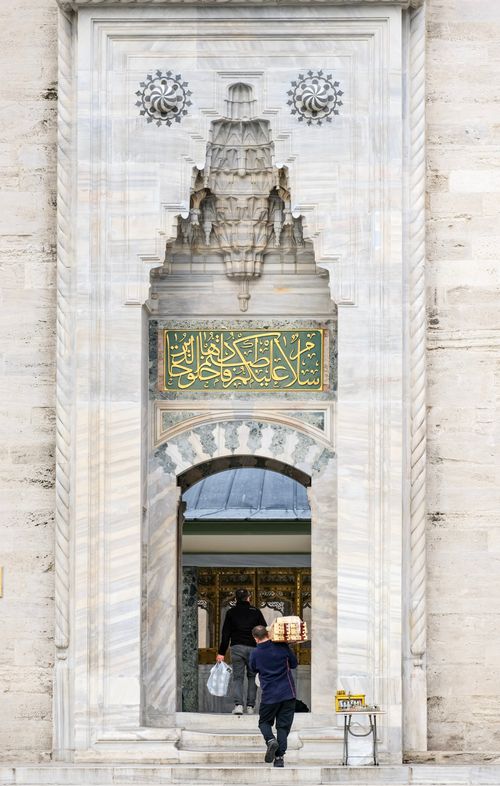 Free A grand mosque entrance featuring Arabic calligraphy and intricate architecture. Stock Photo