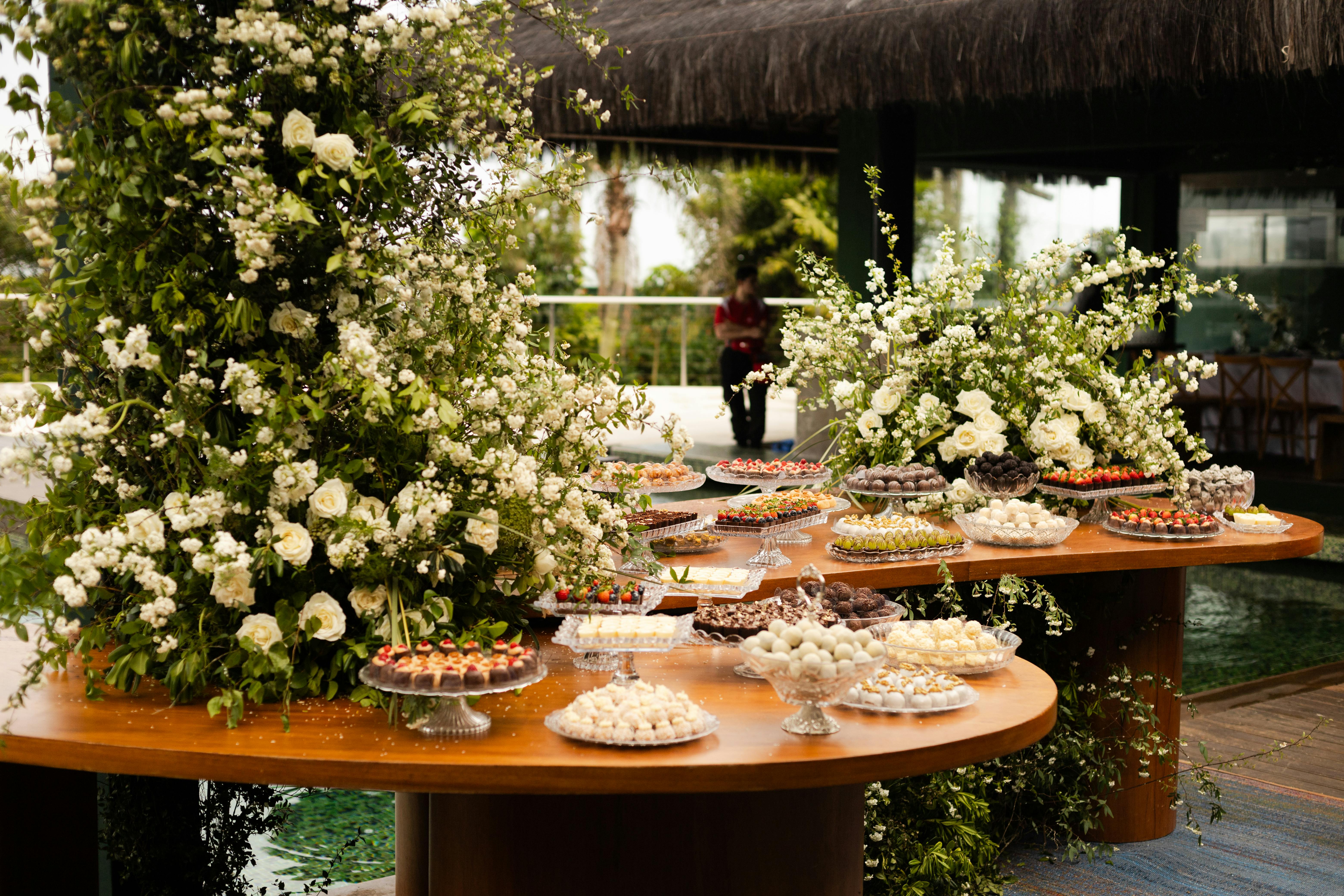 在婚宴上，优雅的花卉装饰与各种甜点共同营造出一个浪漫而温馨的氛围