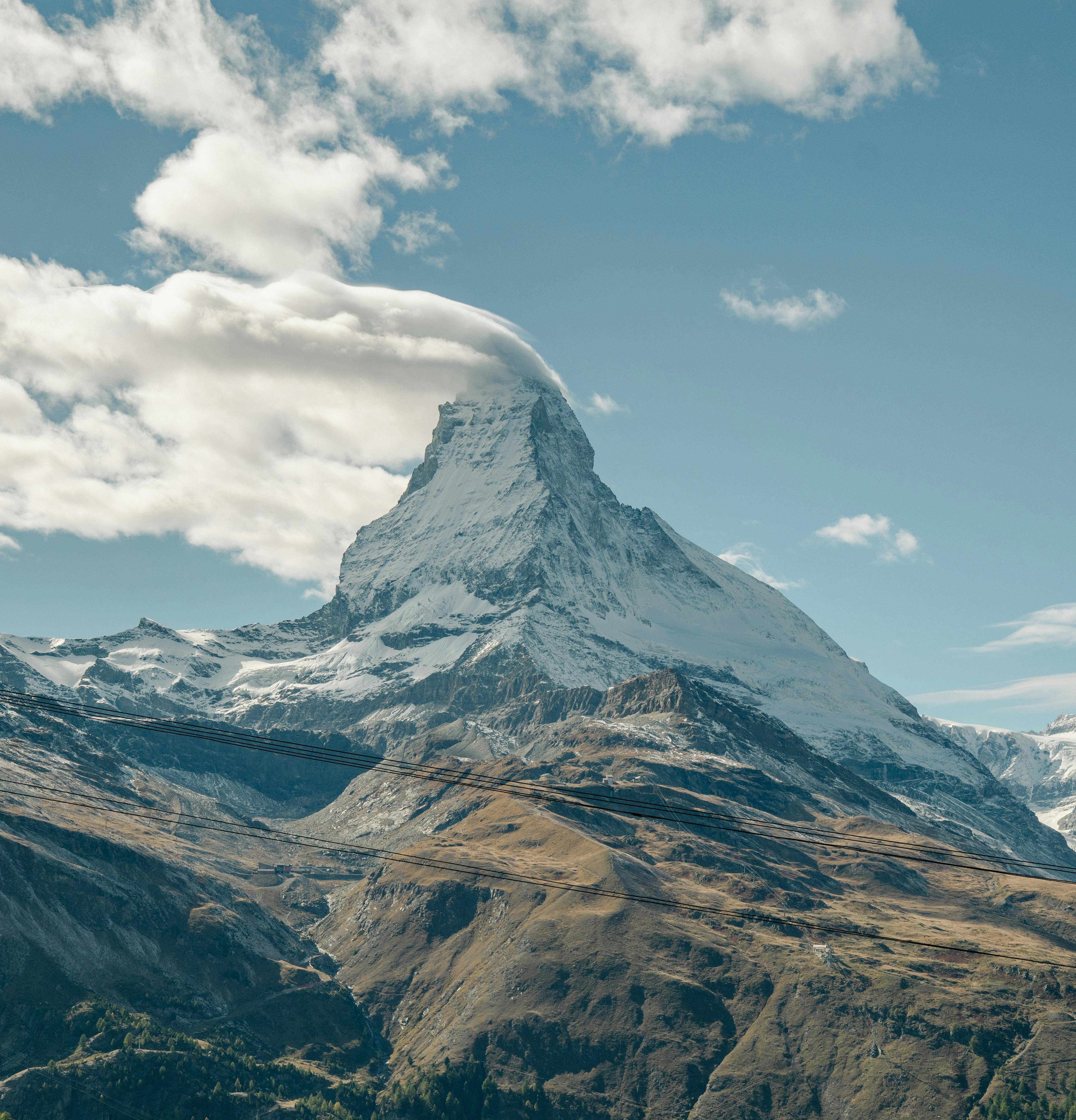 Stunning view of the Matterhorn in Zermatt, Switzerland with a cloud-capped peak on a clear day.