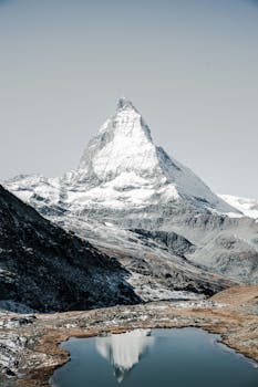Stunning view of the iconic Matterhorn mountain reflecting in a tranquil alpine lake in Zermatt, Switzerland.