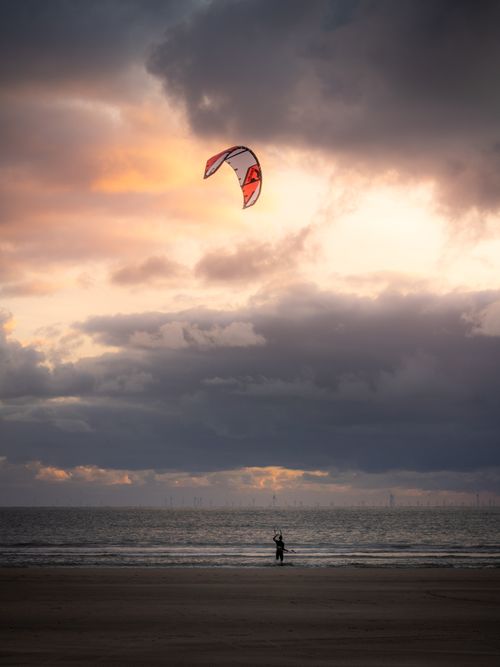 Free Kitesurfer enjoying a vibrant sunset at IJmuiden beach, Netherlands. Stock Photo