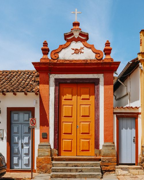 Free Vibrant colonial building with orange doors and ornate detailing under clear blue sky. Stock Photo