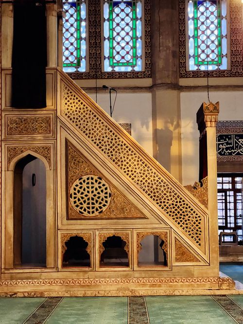 Free A detailed view of a mosque pulpit with intricate geometric patterns and stained glass. Stock Photo