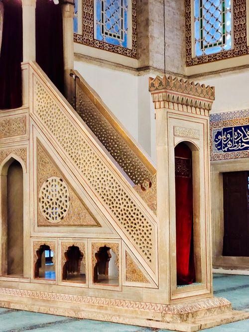 Free Beautifully carved wooden minbar with lattice design in a mosque interior, showcasing Islamic architecture. Stock Photo