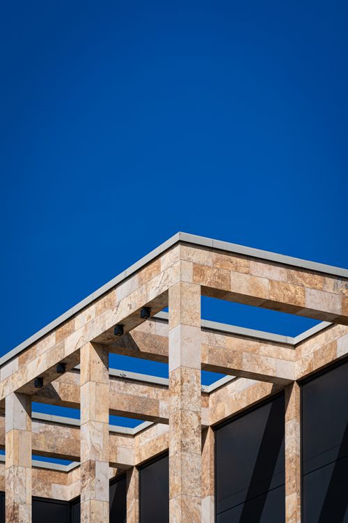 Free Geometric modern architectural structure with stone and clear blue sky. Stock Photo
