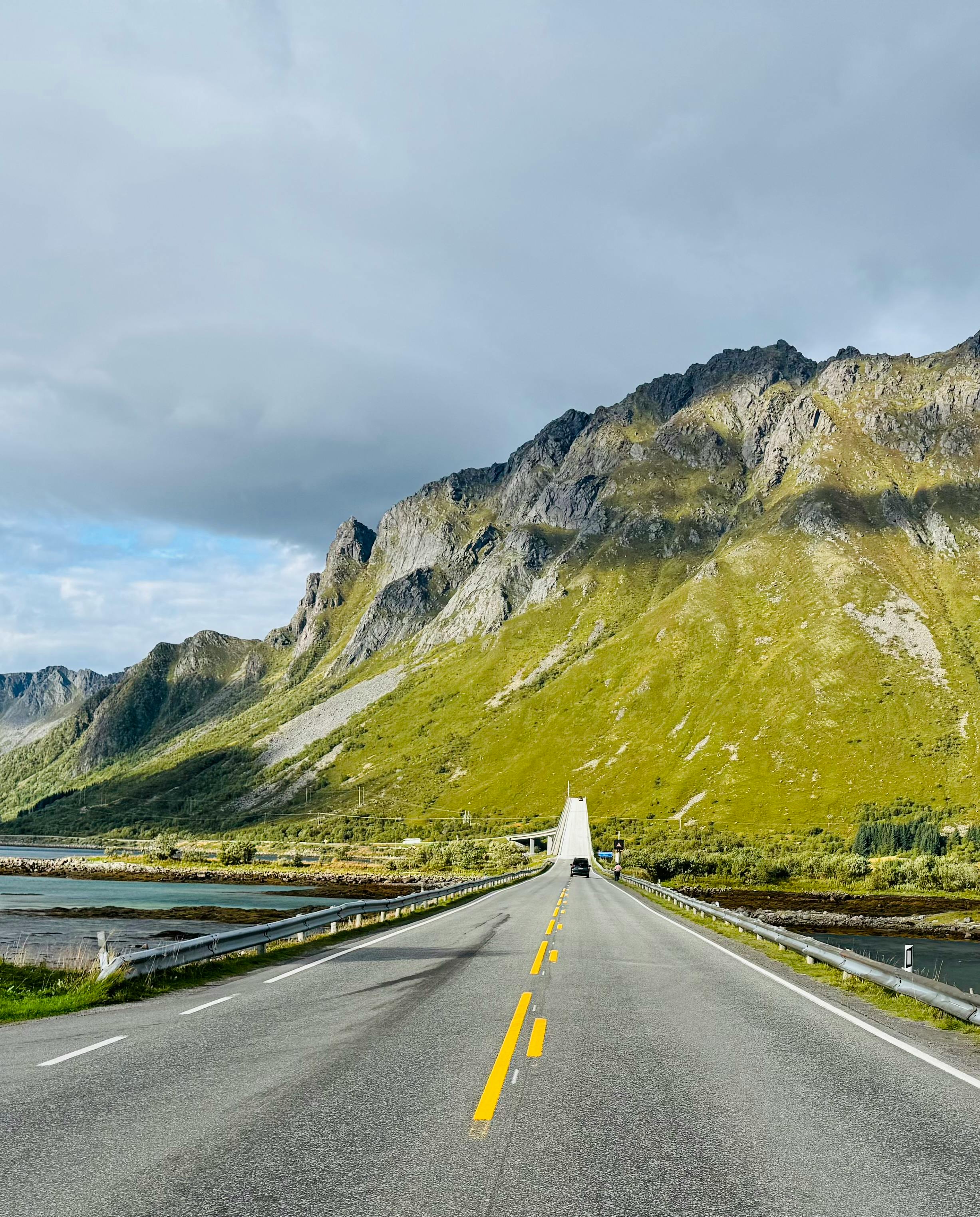 A breathtaking view of an empty road leading through Nordland's stunning mountainous landscape.