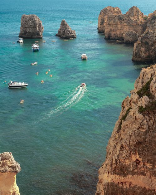 Free Discover the breathtaking coastal cliffs and turquoise waters of Lagos, Portugal. Perfect for travel enthusiasts. Stock Photo