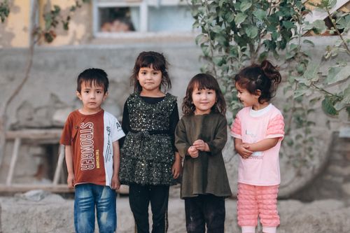 Free Four children standing outdoors in casual clothing, showcasing friendship and joy. Stock Photo