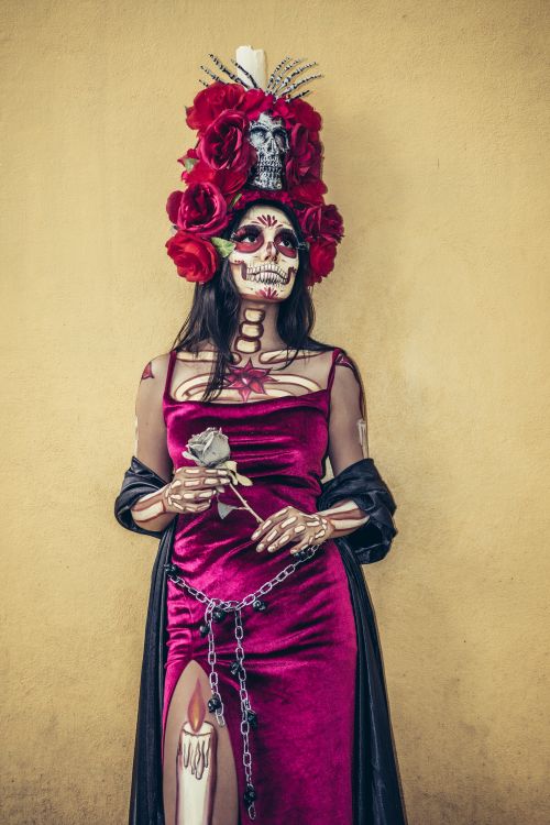Free Person in vibrant Day of the Dead attire with intricate makeup and red rose headdress. Stock Photo