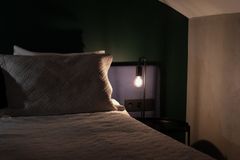 Comfortable bedroom with soft lighting and cozy atmosphere, featuring a bed and a lit bedside lamp.