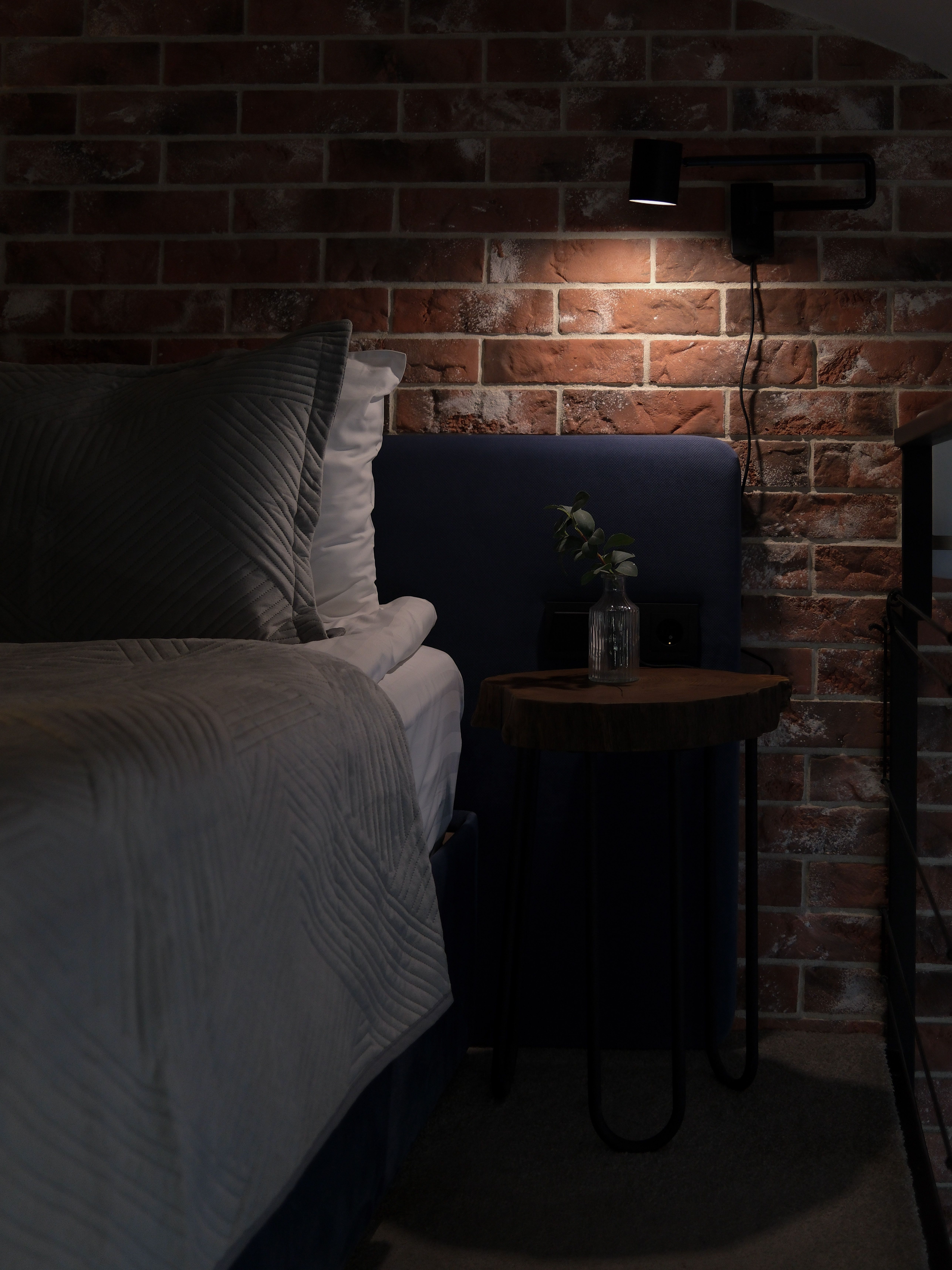 Intimate bedroom with brick wall and soft lighting, perfect for restful nights.