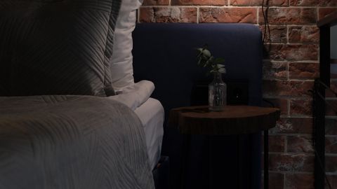 Intimate bedroom with brick wall and soft lighting, perfect for restful nights.