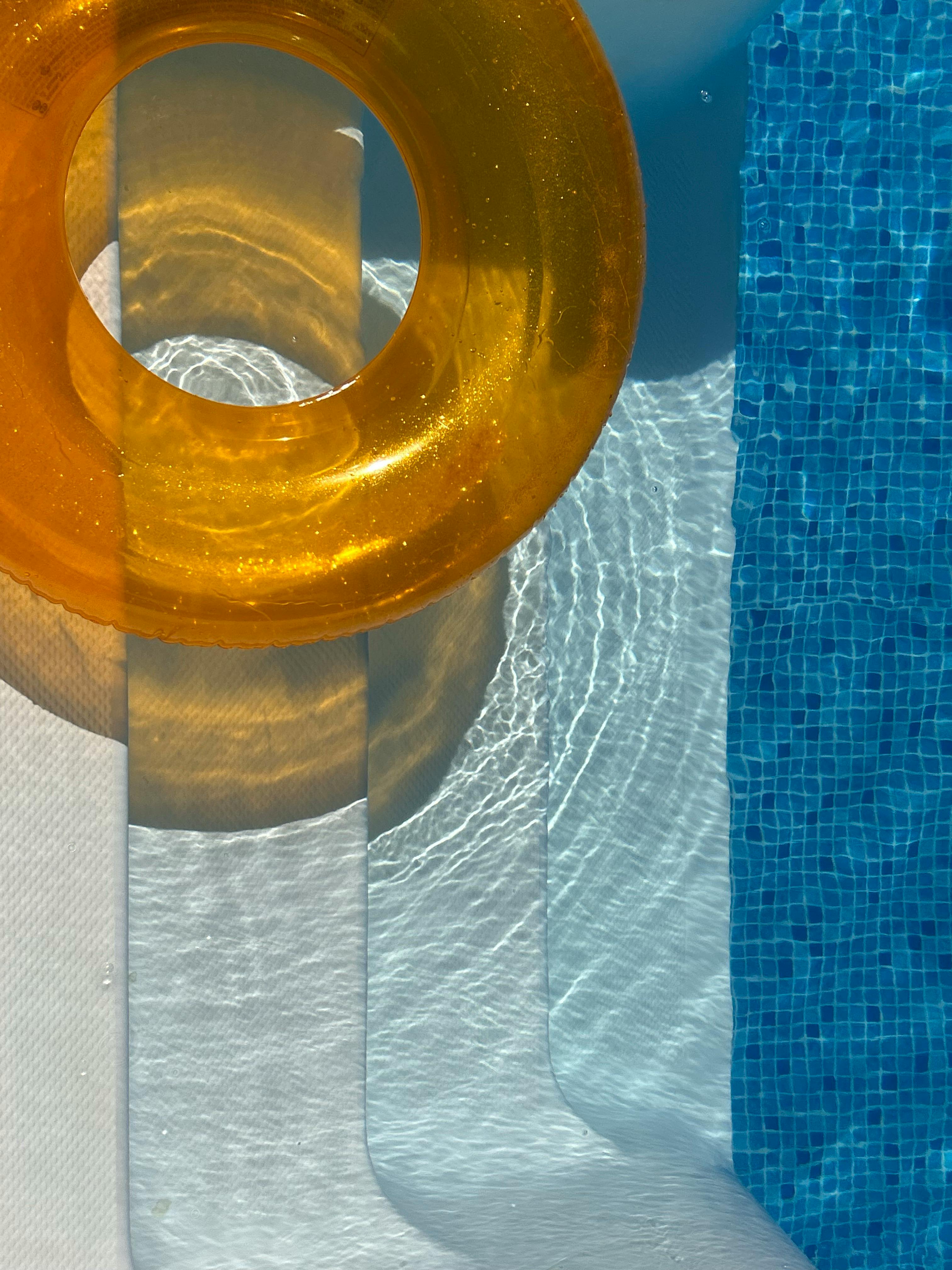 Vibrant orange float by a clear blue swimming pool, perfect for summer vibes.