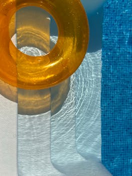 Vibrant orange float by a clear blue swimming pool, perfect for summer vibes.