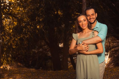 Free A happy couple embracing in a sunlit forest during the day. Warm and loving atmosphere. Stock Photo