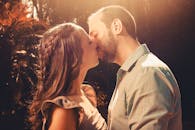 在阳光明媚的花园里，一对恩爱的情侣正沉浸在他们的浪漫时刻