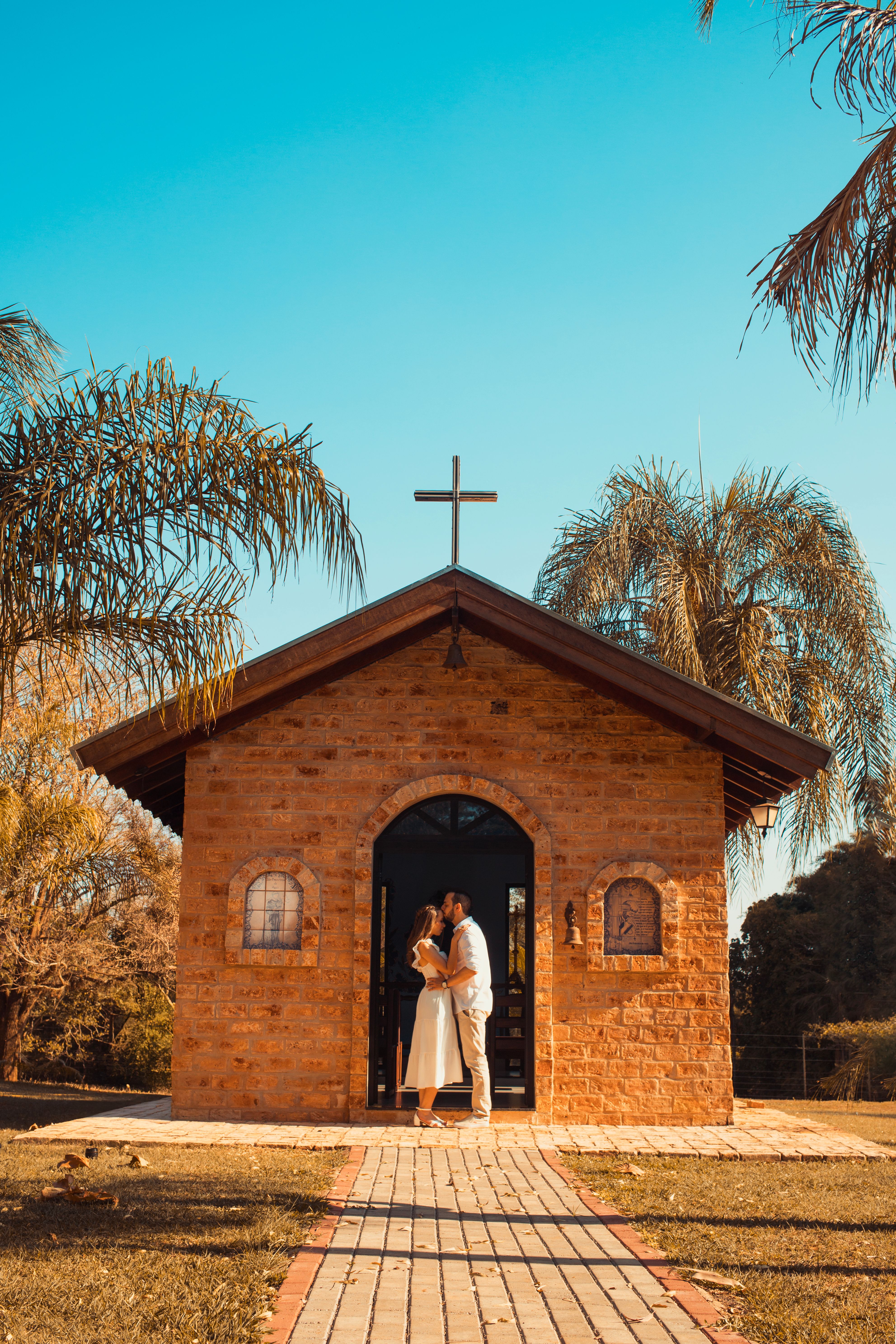Romantic Couple Embracing by a Rustic Chapel · Free Stock Photo