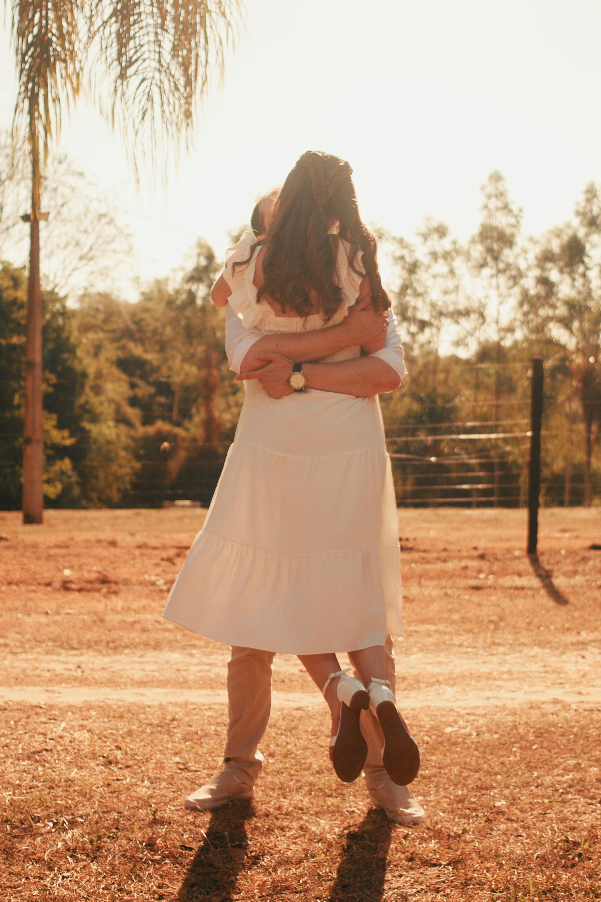 一对夫妇在阳光下的乡村地区享受户外的快乐拥抱