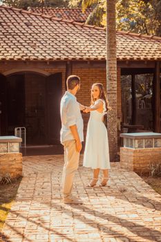 A couple dancing romantically outside a rustic building under natural sunlight. - Fotografer Sidoarjo