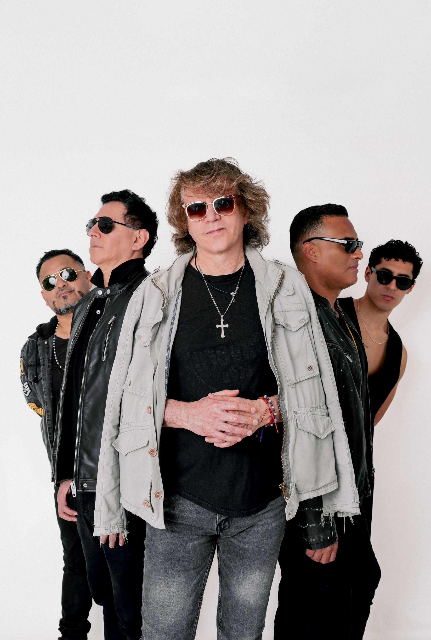 A fashionable group of musicians posing confidently in sunglasses and casual outfits.