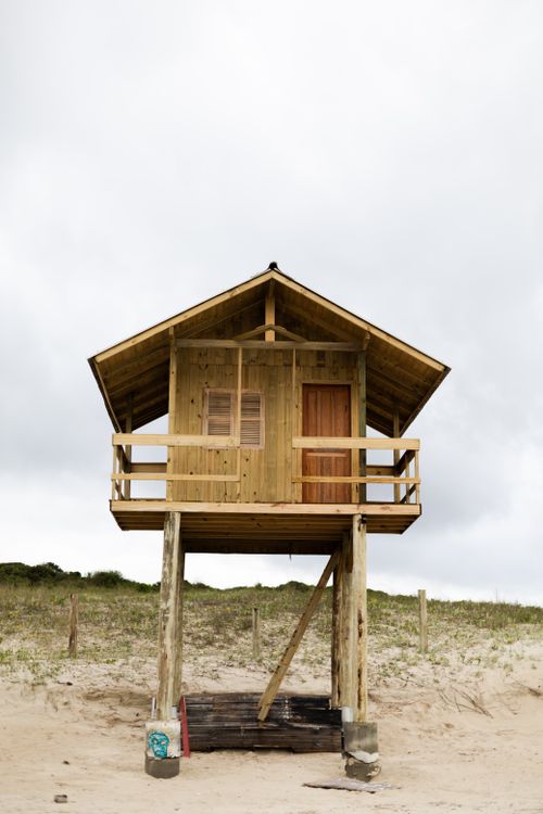 Free A rustic wooden hut on stilts stands on a sandy beach in Florianópolis, Brazil. Stock Photo