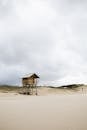 在多云的天空下，弗洛里亚诺波利斯沙滩上，一座宁静的救生员小屋显得格外引人注目