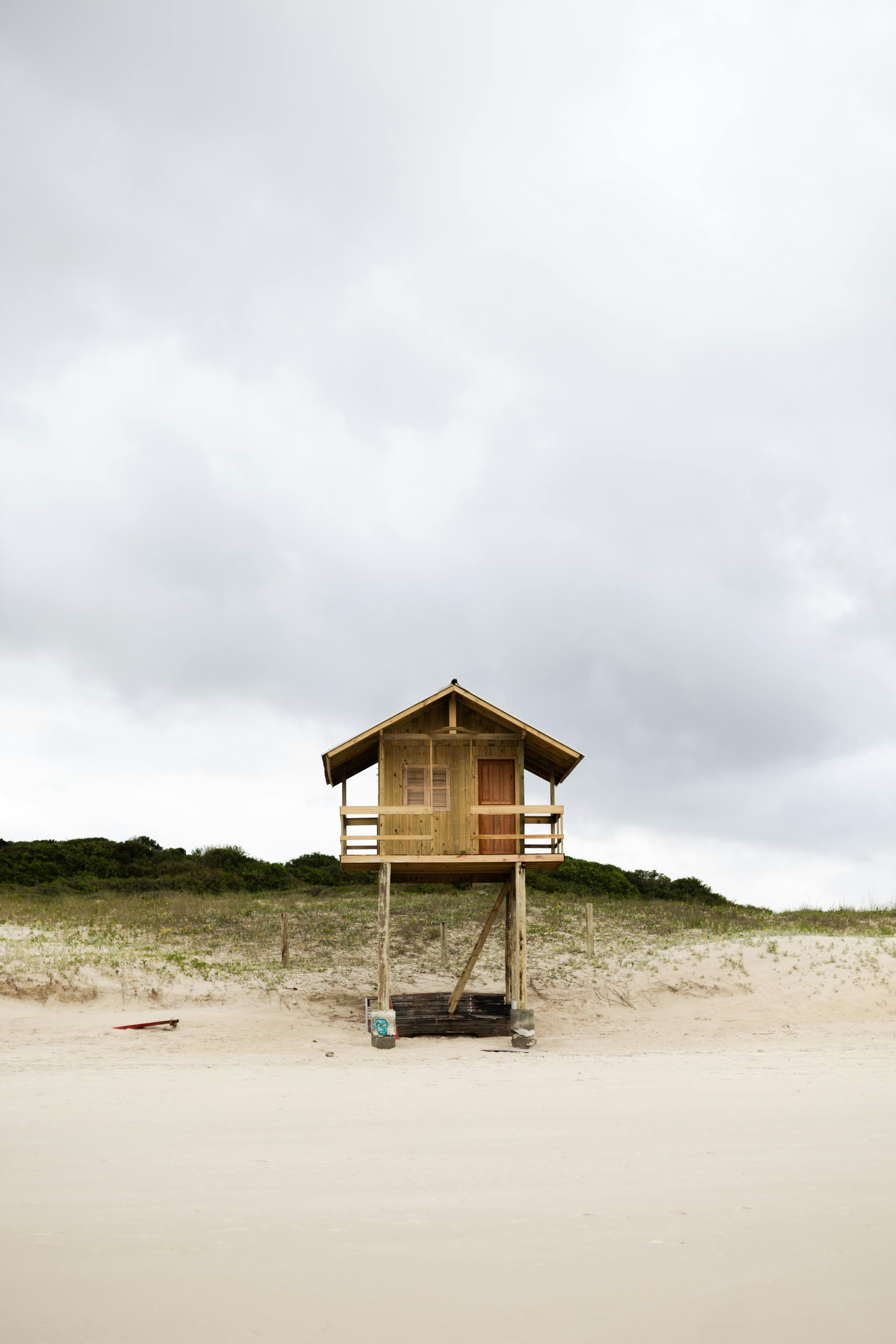 在多云的天空之下，弗洛里安波利斯的沙滩上，一座质朴的海滩小屋独自矗立