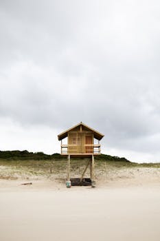 在多云的天空之下，弗洛里安波利斯的沙滩上，一座质朴的海滩小屋独自矗立