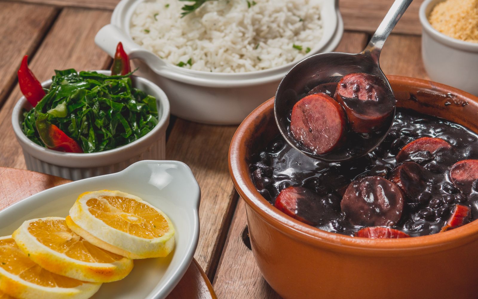 Foto de Feijoada com arroz, couve e laranja