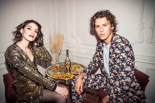 Man Wearing Floral Suit and Woman Wearing Shiny Dress