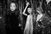 时尚派对上年轻女性庆祝的单色照片，别致而优雅